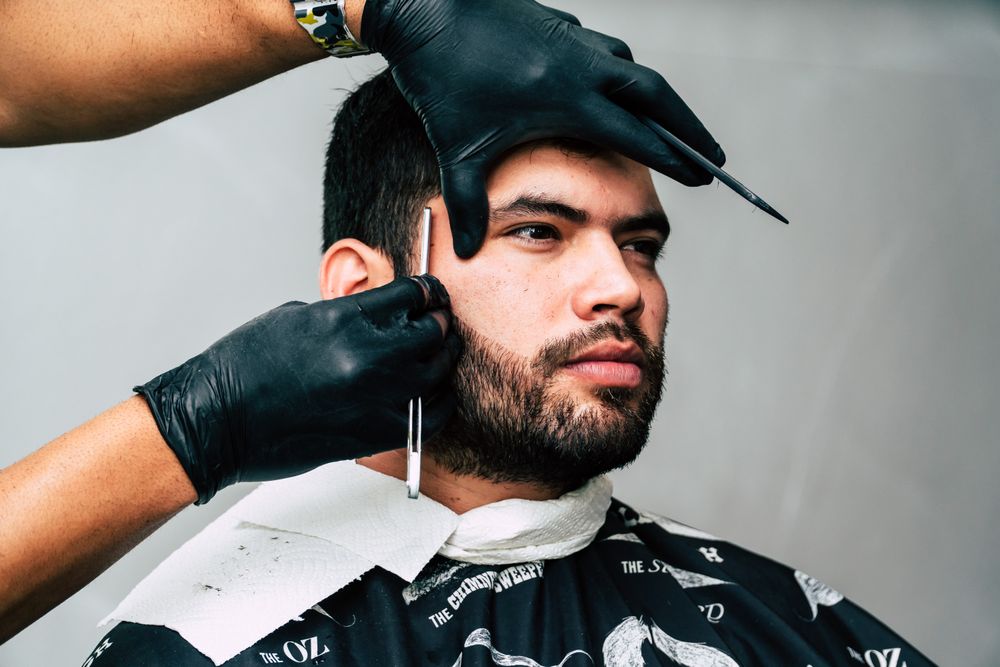 Barber detailing a client's beard with a straight edge